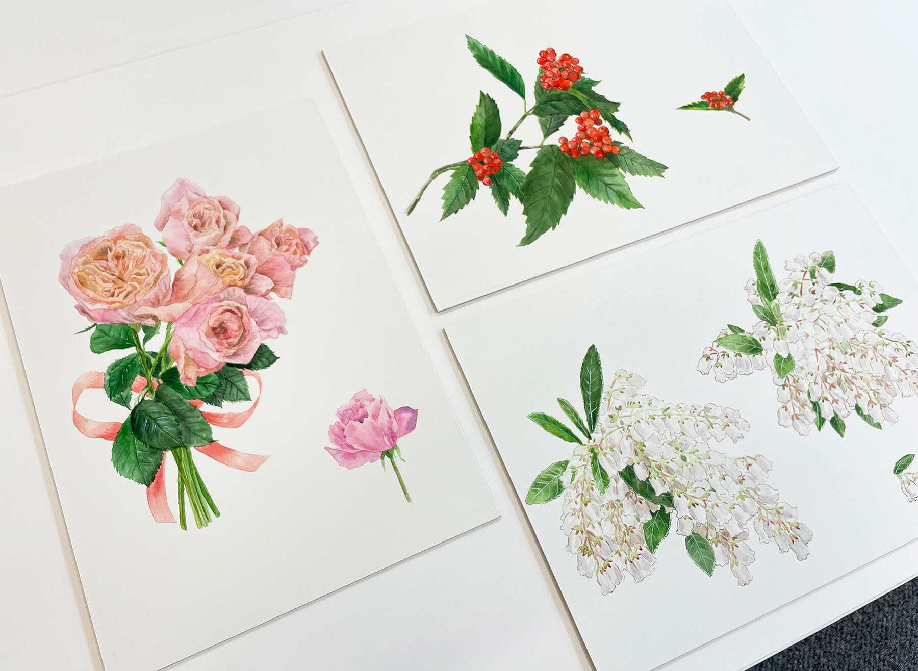 「おもてなしの花シリーズ 第19集」の原画。左から時計まわりに、バラ、センリョウ、アセビ